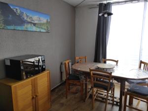 comedor con mesa y TV en La Géla, studio cabine pieds de pistes, en Aragnouet