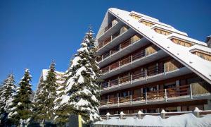 a building with snow covered trees in front of it at STUPENDO 3 CAMERE, PISCINA, BOX, VICINISSIMO PISTE in Prato Nevoso