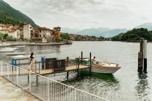 a boat is docked at a dock on a lake at MUSA Lago di Como in Sala Comacina