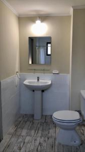 a bathroom with a sink and a toilet and a mirror at Berkana hostel Bariloche in San Carlos de Bariloche +56 photos