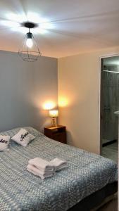 a bedroom with a bed with towels on it at Berkana hostel Bariloche in San Carlos de Bariloche