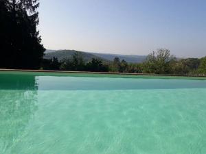 une grande piscine avec vue sur les montagnes dans l'établissement Grand tipis confortable, authentique chalets en rondins et belle maison Périgourdine avec piscine et vue Lascaux en Périgord, à Les Farges