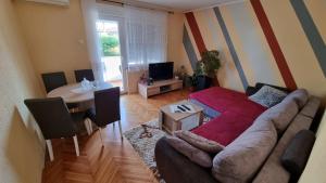 een woonkamer met een bank en een tafel bij Apartman Ori in Umag