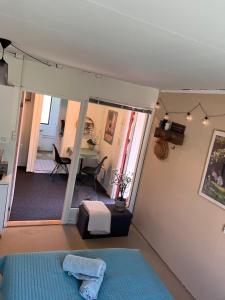 1 dormitorio con 1 cama azul y comedor en Tiny House Marielyst, en Bøtø By