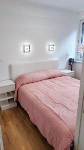 um quarto com uma cama com um cobertor rosa em Apartment Ozare em Slovenj Gradec