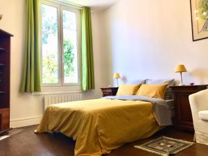 sypialnia z łóżkiem z żółtą pościelą i oknem w obiekcie Petit Appartement dans une maison w Bajonnie