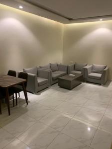 uma sala de estar com um sofá e uma mesa em روز للشقق الفندقية 2 em Al Kharj