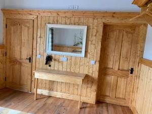 Cette chambre est dotée d'un mur en bois avec un lavabo et un miroir. dans l'établissement Dulrush Fishing Lodge and Guest House, à Belleek