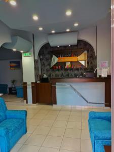 a lobby with two blue chairs and a bar at Hotel Duet in Piteşti