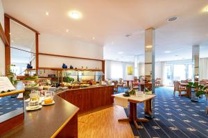 ein Restaurant mit Tischen und Stühlen in einem Raum in der Unterkunft Hotel Am Steinberg in Hildesheim