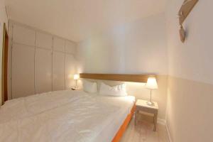 ein kleines Schlafzimmer mit einem Bett und zwei Lampen in der Unterkunft Apartment 261 in Hohegeiß