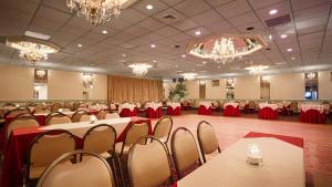 a banquet hall with tables and chairs and chandeliers at West Gate Inn Nyack in Nyack