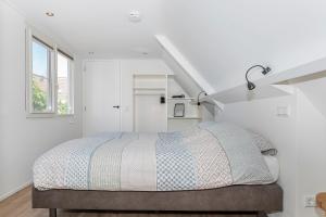 1 dormitorio con 1 cama en una habitación blanca en Vakantiehuis '2bijZee' dicht bij Domburg en strand en Aagtekerke