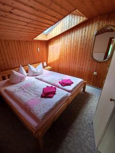 Un dormitorio con una cama con almohadas rosas. en Ferienhaus Hering, en Neu Porschdorf