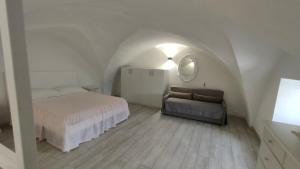 1 dormitorio con cama, sofá y espejo en Dimora Giorgilla, en Martano