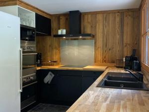 una cucina con un lavello e un piano di lavoro di Chalet 6 chambres avec jacuzzi et parking, La Tania - FR-1-513-72 a La Tania Altre 4 foto