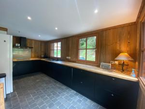 una cucina con mobili in legno e un piano di lavoro di Chalet 6 chambres avec jacuzzi et parking, La Tania - FR-1-513-72 a La Tania