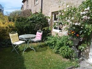 two chairs and a table in a garden at Orchard Cottage in Ripon