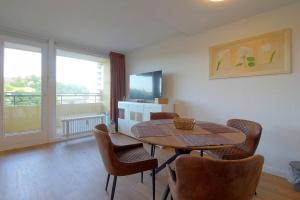 een woonkamer met een tafel en stoelen en een televisie bij Apartment 449 in Hohegeiß
