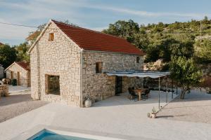 uma casa de pedra com uma piscina em frente em Villa Terra Meera em Skradin