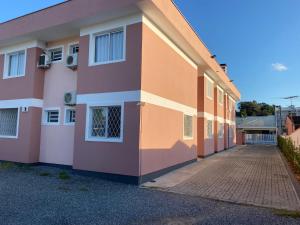 różowo-pomarańczowy budynek z chodnikiem w obiekcie RCM Vilas - STUDIO n 05 w mieście Joinville