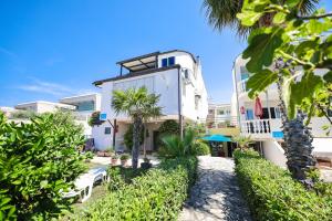 a building with palm trees in front of it at Apartments Malic in Petrcane