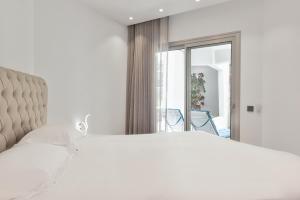 a white bedroom with a large bed and a window at Ancor 0-1 POOL VIEW 2B in Palm-Mar +11 photos