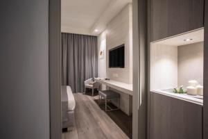 a hotel room with a bed and a desk and a mirror at Hotel Rex in Livorno