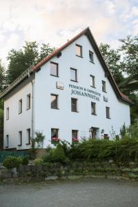 ein weißes Gebäude mit einem Schild an der Seite in der Unterkunft ApartOne Land-Hotel in Sebnitz