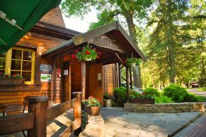 a building with flowers on the front of it at Wioska Indiańska River Park Zator SPA RESORT in Zator