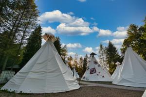a row of white tents with trees in the background at Wioska Indiańska River Park Zator SPA RESORT in Zator +20 photos