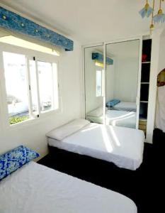 a bedroom with two beds and a mirror at SUPER ATICO PLAYA de MOJÁCAR - AMAZING PENTHOUSE at MOJÁCAR BEACH in Mojácar