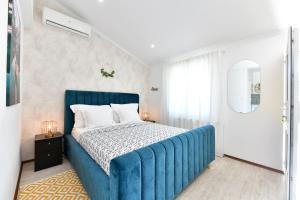 a bedroom with a blue bed with a blue blanket at Apartments Green Park in Rakovica