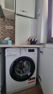 eine Waschmaschine und einen Trockner in einer Küche mit einer Theke in der Unterkunft Theo- Mamaia Nord in Mamaia Nord – Năvodari
