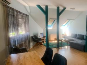 a living room with a blue couch and a table at Rooftop Corner Siófok in Siófok