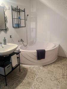 a white bathroom with a tub and a sink at Rooftop Corner Siófok in Siófok