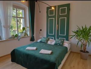 ein Schlafzimmer mit einem grünen Bett mit zwei Handtüchern darauf in der Unterkunft Apartament Szmaragdowy in Jelenia Góra