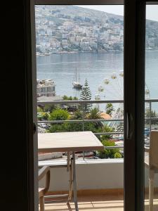 een kamer met een tafel en uitzicht op het water bij Saranda relax apartments in Sarandë