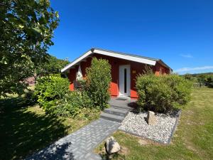 una casa roja con una pasarela que conduce a ella en Ferienanlage Bullerbü, en Lohme