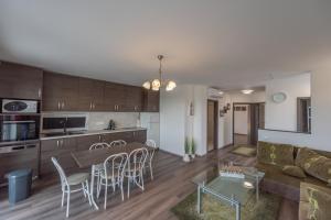 uma cozinha e sala de estar com um sofá e uma mesa em Bridgiet Home Apartman em Cserszegtomaj