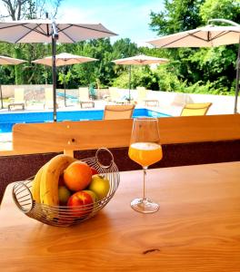 kosz owoców i kieliszek wina na stole w obiekcie Apartmani Vesna w mieście Opric
