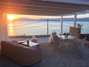 a patio with a table and chairs and a view of the ocean at HydraVista (Pearl) in Hydra