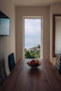 a bowl of fruit on a wooden table with a window at VILA PUPA , Elešec in Ohrid