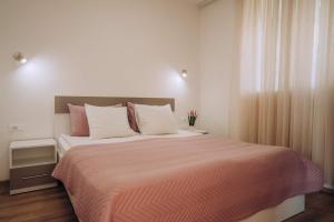 a bedroom with a large bed with a orange blanket at VILA PUPA with Lake view - Elešec in Ohrid