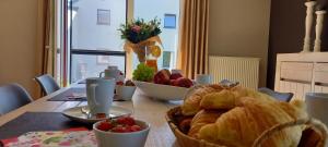 a table with a basket of bread and fruit on it at Sur les Hauteurs in La Roche-en-Ardenne