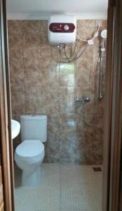 un baño con inodoro y ducha en The Kulawi Villa & Resort, en Puncak