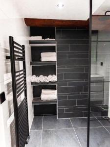 een inloopkast met zwarte tegels en witte handdoeken bij Appartement Wolf in Alkmaar
