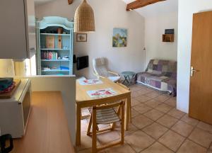 eine Küche und ein Wohnzimmer mit einem Tisch und einem Sofa in der Unterkunft Tiny House Belleraze in Saint-Jean-de-Minervois