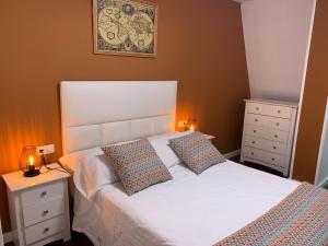 a bedroom with a white bed with two pillows at Home Sweet Home in Caldas de Reis
