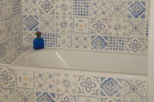 una bottiglia blu appoggiata sopra una vasca da bagno di La Grange Dîmière, près de Tours a Saint-Genouph Altre 23 foto